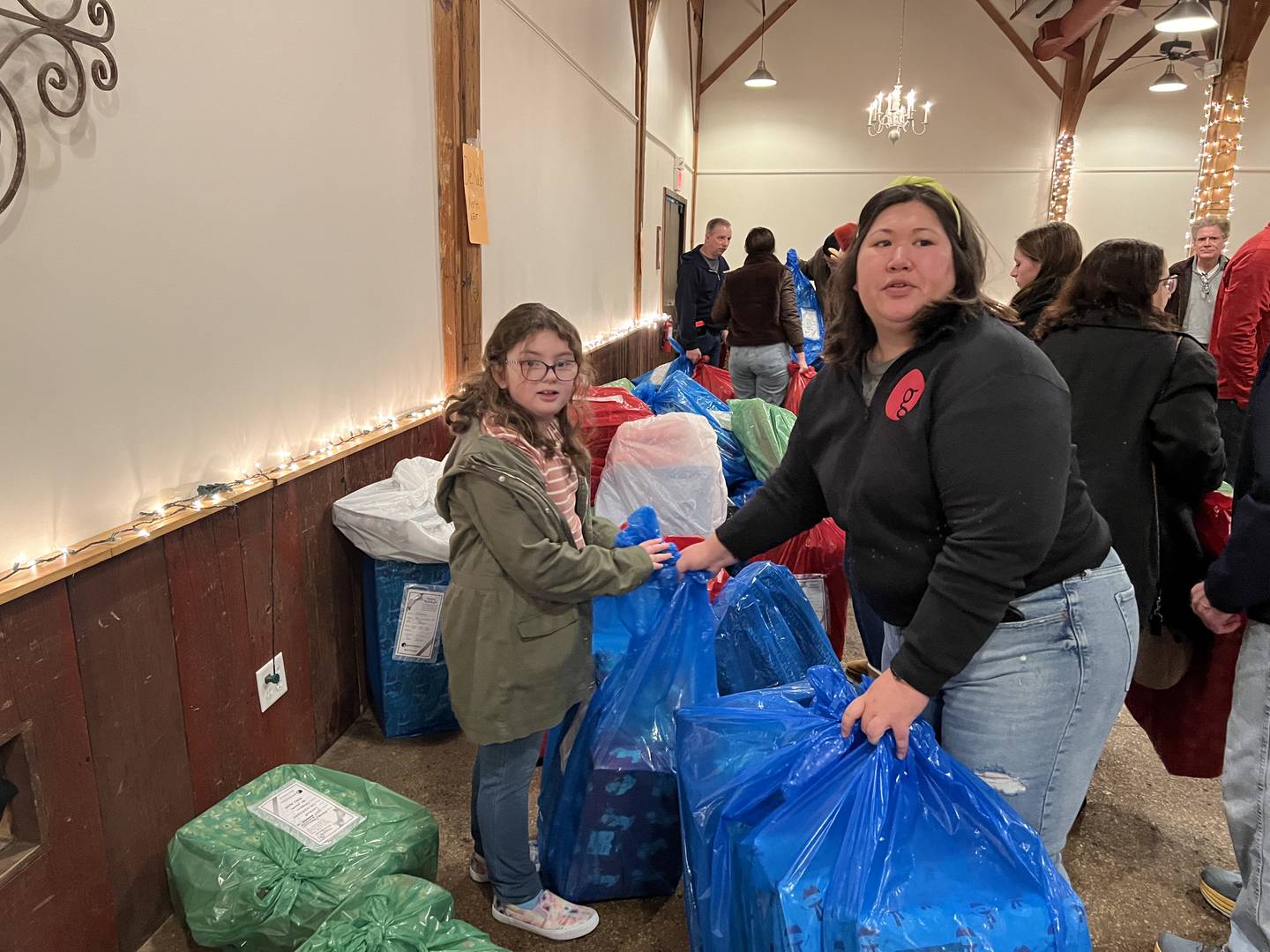 Everly Skudlarek, left, and Kelli Meserole collected gifts at Blumen Gardens on Dec. 24, 2023, to deliver to children in DeKalb as Goodfellows.