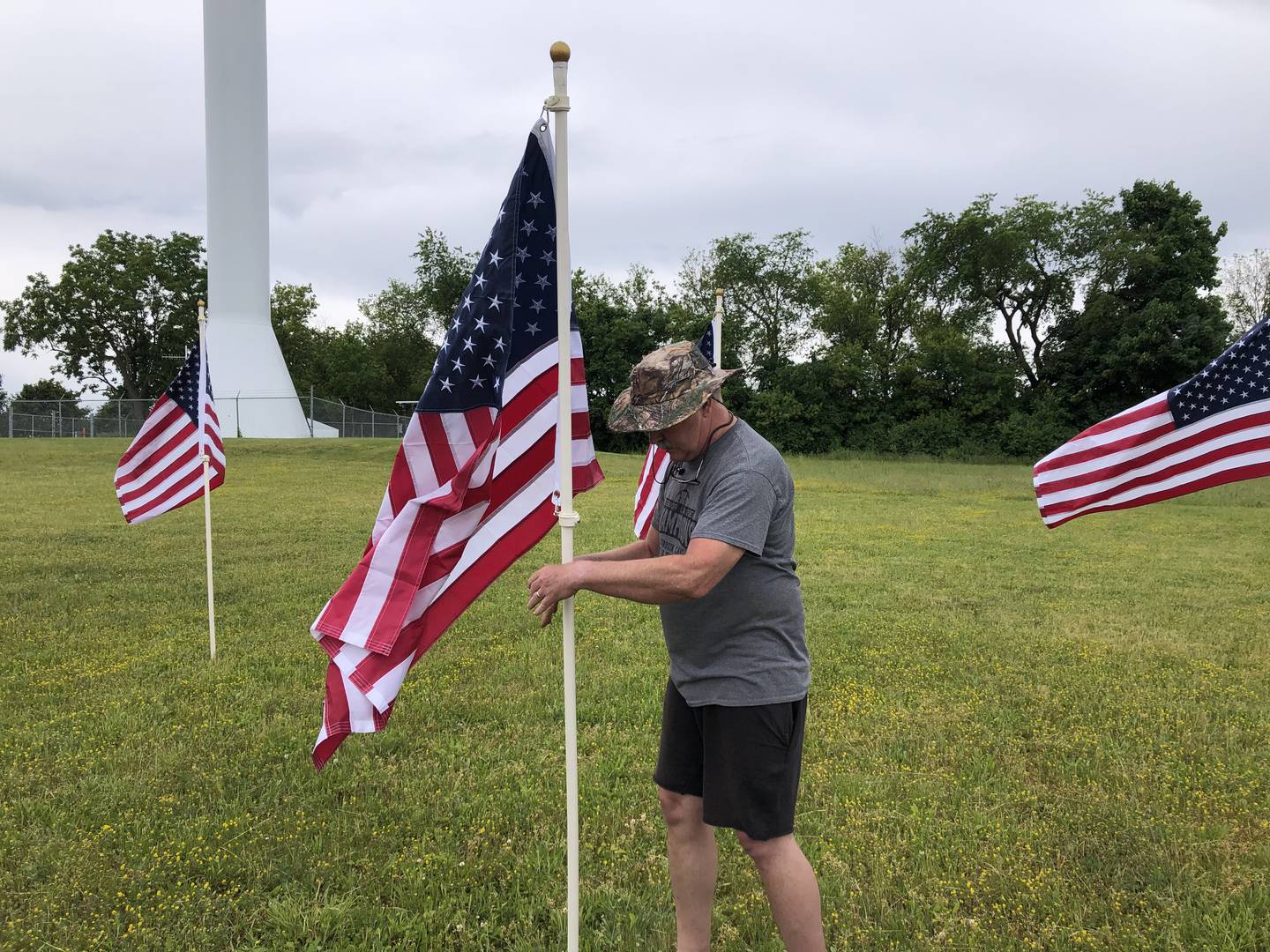 Matt Charlier helps set up the Field of the Fallen flag display in Cary on May 24, 2024, to commemorate fallen servicemen and women from Illinois during Memorial Day weekend.