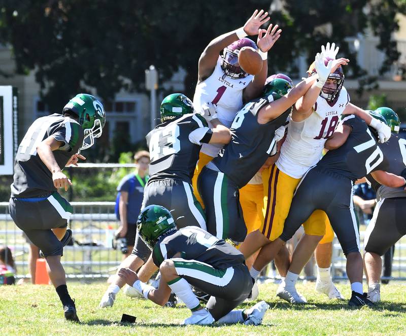 Loyola's Donovan Robinson (1) blocks a field goal attempt by Glenbard West kicker Aidan Adachi (left) during a game on September 7, 2024 at Glenbard West High School in Glen Ellyn.