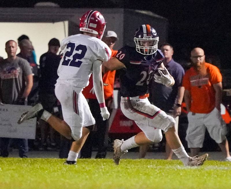 Oswego’s Dylan King (20) carries the ball against West Aurora's Kellen Younie (22) during a football game at Oswego High School on Friday, Sept. 29, 2023.