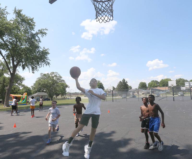 Kaden Miscevic drives to the hoop while playing with youth during the Juneteenth event on Wednesday June 19, 2024 at Kirby Park in Spring Valley.