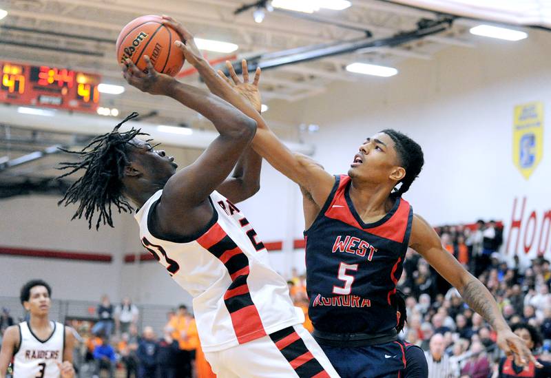 West Aurora defender Terrence Smith (5) takes on Bolingbrook's Jason Lawani but gets called for the foul during a class 4A regional championship basketball game at Yorkville High School on Friday, Feb. 23, 2024.