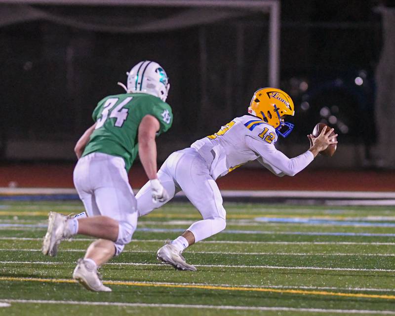 Lyons Township's Dom Pisciotti (12) jumps on the ball after fumbling the ball during the game on Friday Oct. 18, 2024, while traveling to take on York High School in Elmhurst.