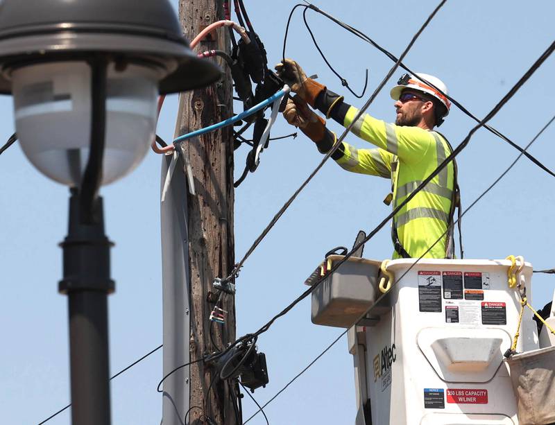 A ComEd employee works on a power line Monday, July 15, 2024, on West Page Street in Sycamore. High Winds and heavy storms hit DeKalb County overnight causing downed trees and power outages in the area.