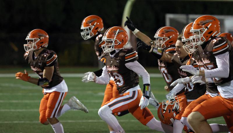 Hersey players rush to the sideline s they celebrate their win over Wheaton Warrenville South during the IHSA Class 7A playoffs Saturday October 28, 2023 in Arlington Heights.