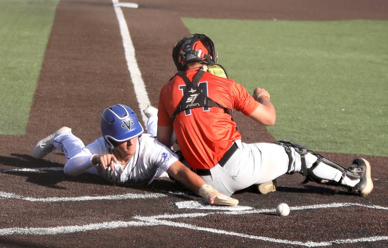 Geneva’s Joey Cosentino slides safely into home plate as St. Charles East catcher Mac Paul attempts the out during a game at Judson University in Elgin on Tuesday, May 7, 2024.