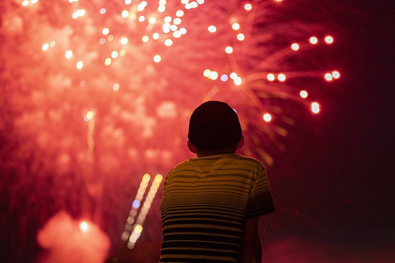 A youngster watches as the grand finale of the fireworks kick off Friday, June 30, 2023 from the lower dam in Rock Falls.