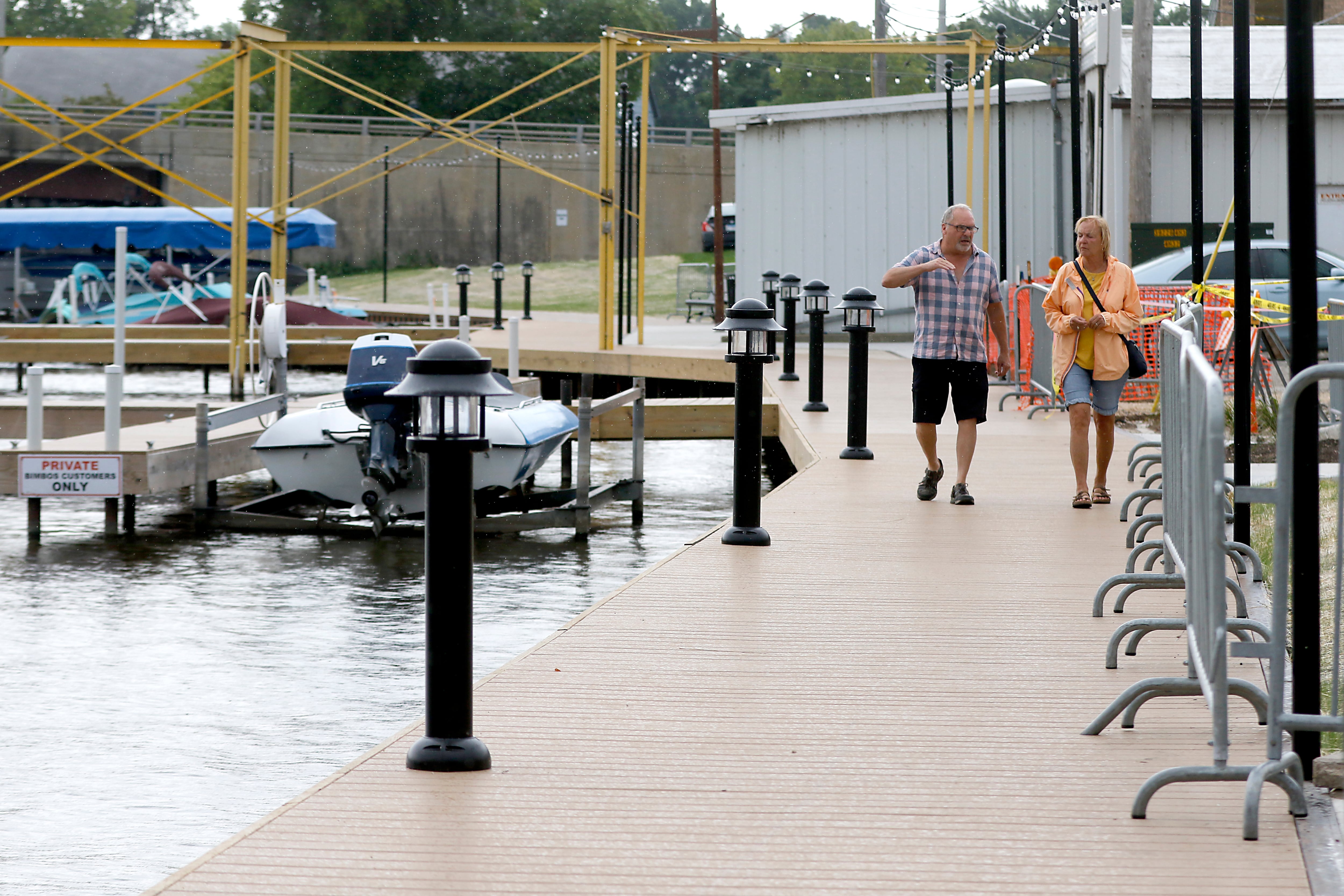 Scott and Jennie Hoffmann walk along a recently opened section of the McHenry Riverwalk on Tuesday, July 24, 2024. With the opening of this section between Pearl Street and West Elm Street you can now walk along the Fox River and Boone Creek all the way from Green Street to Webers Park.