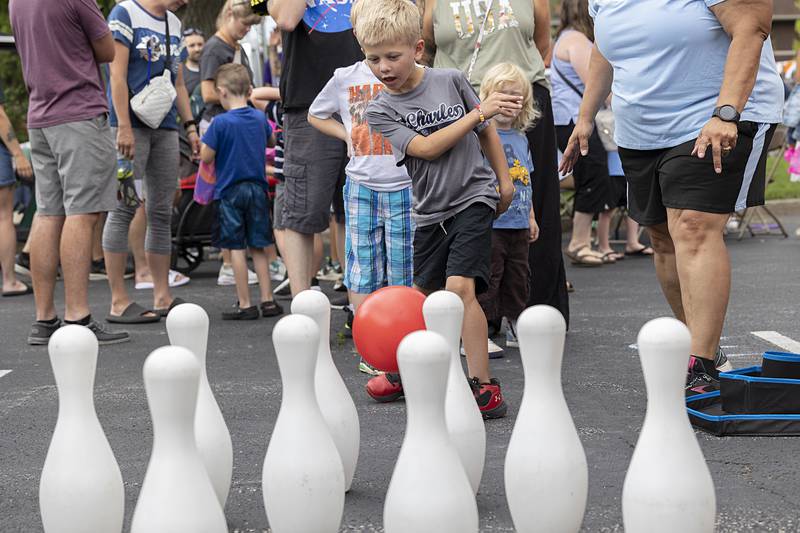 Hudson Mesick, 6, of Dixon fires a ball towards some pins Friday, July 5, 2024 during a family fun event for Petunia Fest. The event, held in the First Presbyterian Church parking lot, was jammed with families playing games and enjoying the pleasant evening weather.