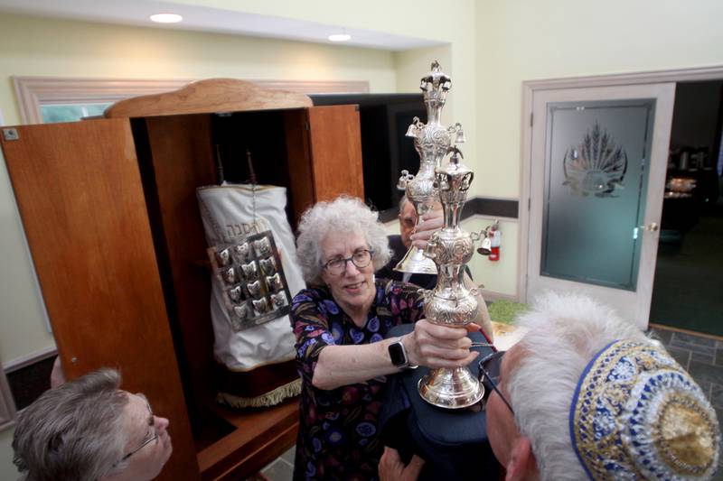 Rabbi Maralee Gordon assists members in placing Torah Scrolls in their new ark as the McHenry County Jewish Congregation moved sacred items to the Tree of Life Unitarian Church in McHenry on Sunday, August 18.