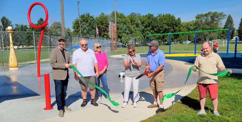 Ottawa city employee Bill Boettcher (with scissors) cuts the ribbon at Thursday's grand opening of the newly-renovated Peck Park, while city officials look on.