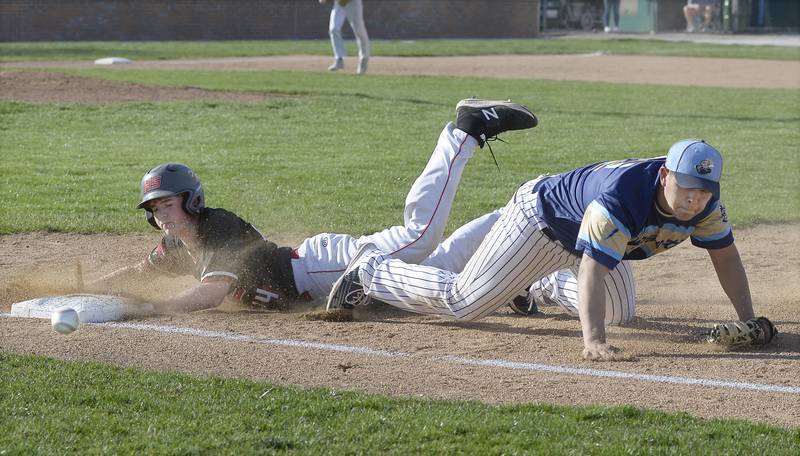 The ball gets away from Marquette1st baseman Sam Mitre as Henry Senachwine’s Mason Johnson dives back into first in the 2nd inning on Tuesday, April 11, 2023 in Ottawa.