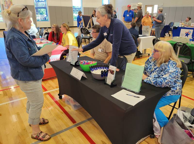 Patty Wheeler (left) of Ottawa speaks with Bob Anselme, Erin Hanna and Rhonda Brown of Alternative Bridges Community Center at the Ottawa Volunteer Fair at the YMCA on Monday.