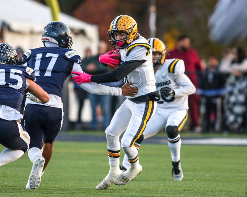 St Laurence's Connor Engstrom (11) avoids the IC Catholic defense during Class 4A third round playoff football game between St Laurence at IC Catholic Prep.  Nov 11, 2023.