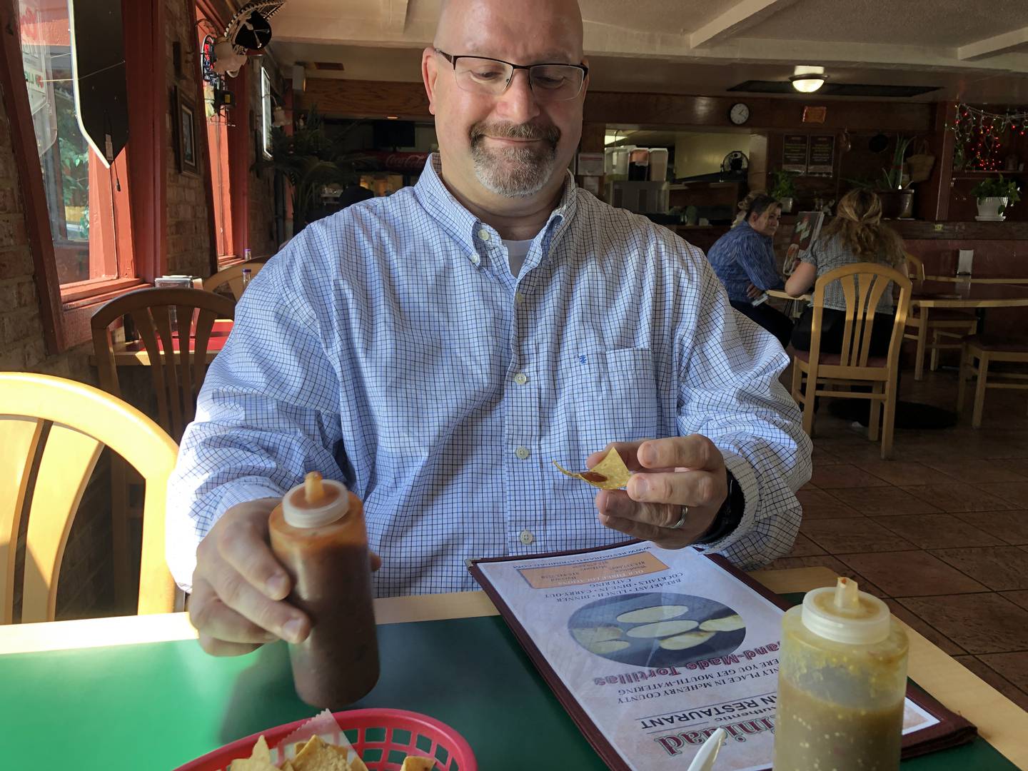 Lou Leone, Harvard's city administrator, goes for the hot sauce at La Trinidad on Thursday, Sept. 12, 2024. The Mexican restaurant is one of seven in Harvard now part of Naturally McHenry County's Tacos, Tamales and Tortas Trail. The promotion is set to kick off on Monday, Sept. 16, 2024.