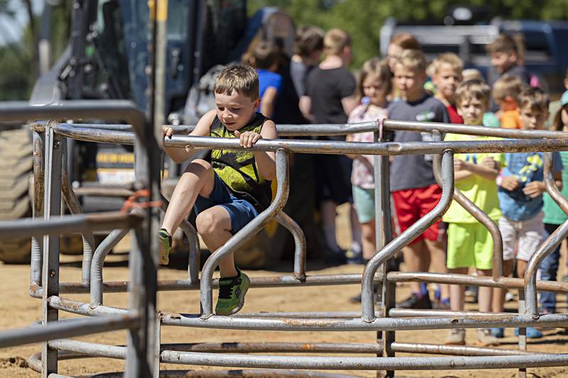 Griffin McPeek, 7, of Kent squeezes through an obstacle Saturday, August 12, 2023 while competing in the Ninja Farmer course at the Carroll County Fair.