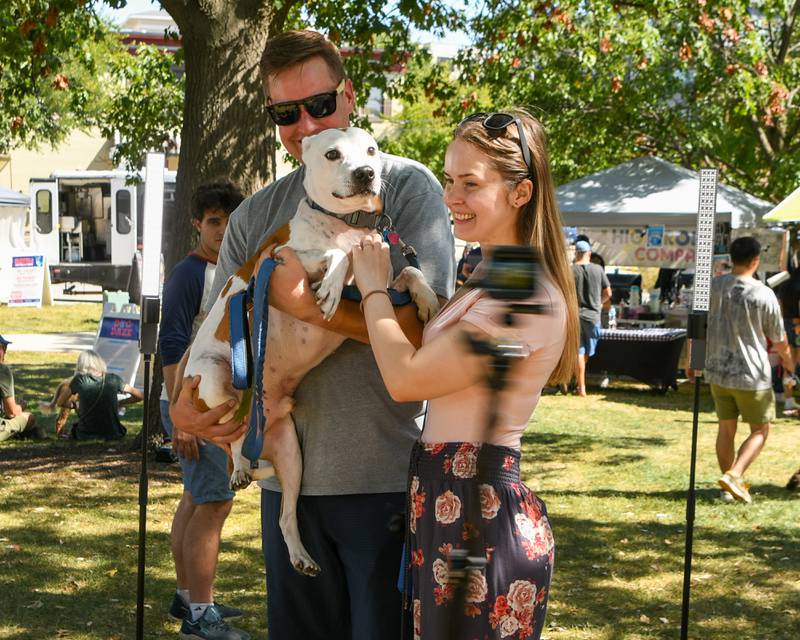 Brandon Rokosh holds, 7 year old pit mix, along with his wife Laura Rokosh of Elmhurst as they get a 360 degree photo taken during the Dog Daze event on Saturday Sept. 14, 2024, held at Fishel Park in Downers Grove.