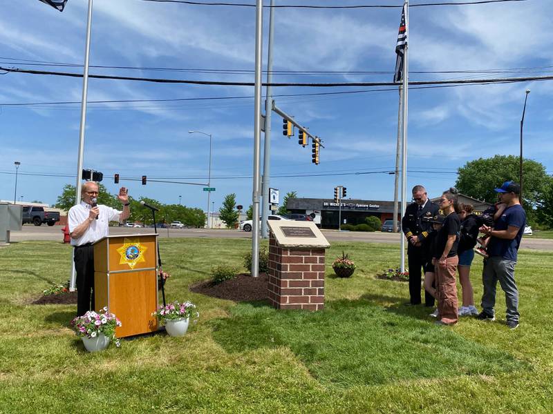 DeKalb resident, veteran and events organizer Michael Embrey (left) thanks the crowd for coming after DeKalb County Sheriff Andy Sullivan (right) joined by loved ones of the late Deputy Christina Musil unveiled a memorial plaque  to honor Musil at the new first responders memorial outside Isaac Executive Suites, 2675 Sycamore Road, DeKalb, during a dedication ceremony held Sunday, May 19, 2024.