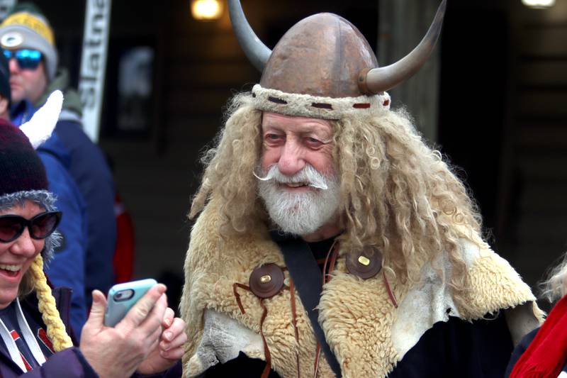 Marty “The Viking” Knapp of Fox River Grove takes pictures with others during the 119th Norge Annual Winter Ski Jump Tournament in Fox River Grove Sunday.