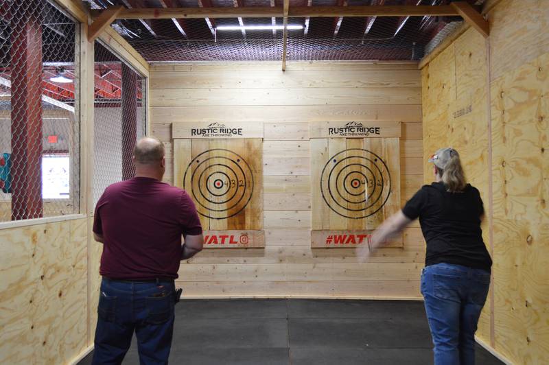 Chris and Cassandra Chapman throw axes during the grand opening of their business, Rustic Ridge Axe Throwing, on May 28. The business is located at 117 N. 4th St., Oregon, and is affiliated with the World Axe Throwing League.