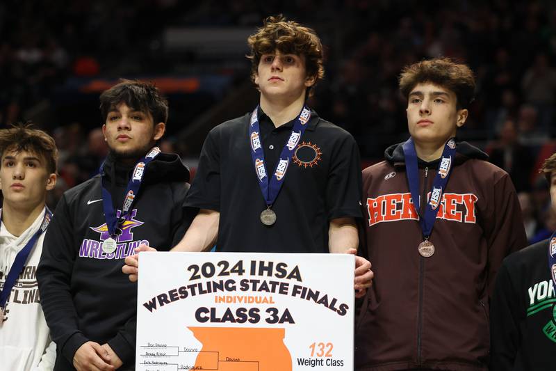 St. Charles East’s Ben Davino stands on the podium after his win over Hononega’s Thomas Silva in the 132-pound Class 3A state championship match on Saturday, Feb. 17th, 2024 in Champaign.