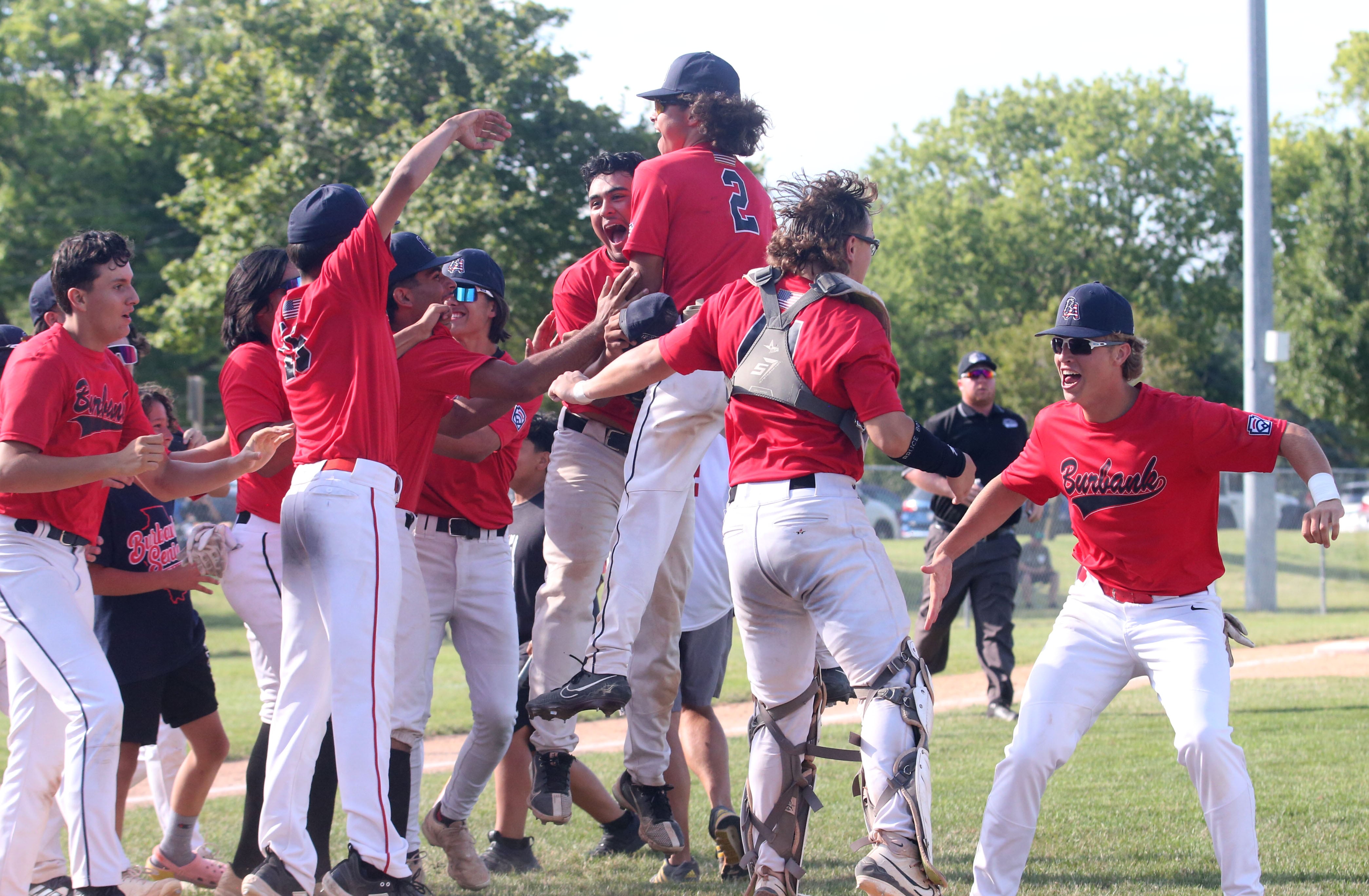 Members of the Burbank Senior League baseball team celebrate after defeating Michigan to win the Central Regional  Baseball Tournament championship game on Thursday, July 18, 2024 at J.A. Happ Field in Washington Park in Peru.