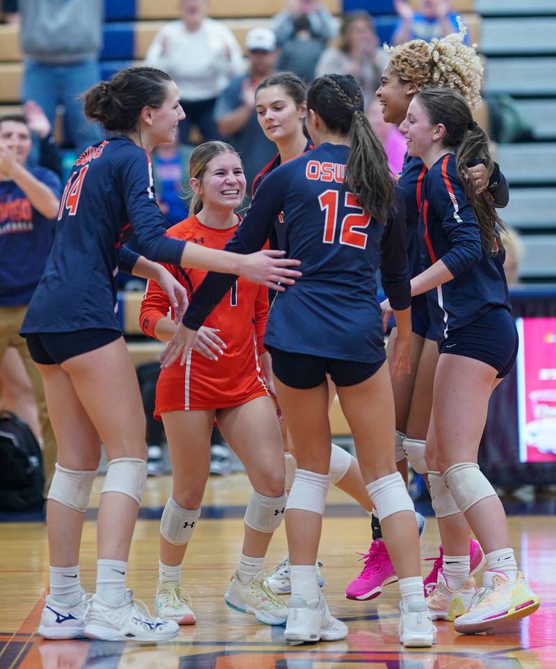 Oswego volleyball players celebrate after defeating Romeoville in two sets at Oswego High School on Tuesday, Oct. 17, 2023.