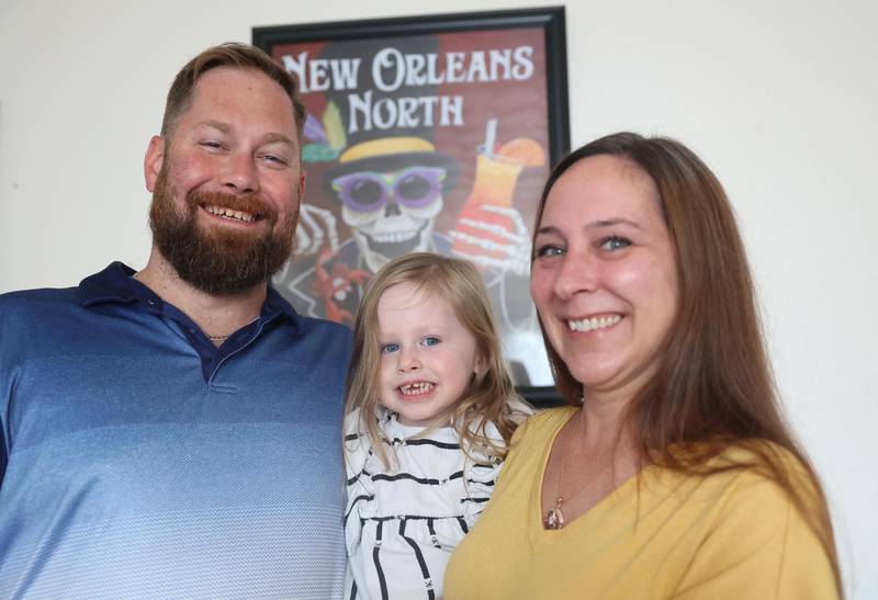 Adam Taylor and Monique Maginel pose for a photos with their 3-year-old daughter Amelia at their home on Wednesday, August, 2024 in Joliet. Adam and Monique met at the New Orleans North festival in 2019 and Adam proposed at the festival last year.