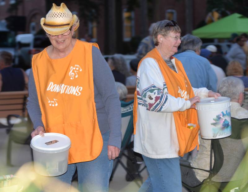 Two volunteers seeks donations from the crowd during a break in the music at the opening night of the Jamboree music series in downtown Mt. Morris on Friday, June 7, 2024. The free concert series continues through the summer each Friday night on the campus.