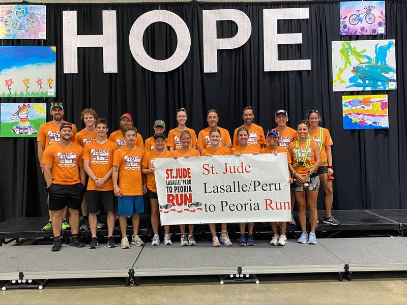 La Salle Peru runners hold up a sign from the St. Jude run.