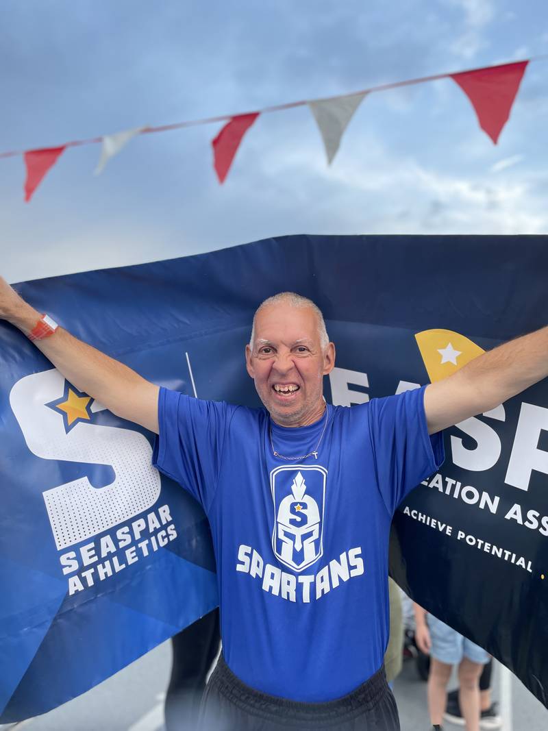 Michael Nowak of Darien carries the SEASPAR banner at the Special Olympics Illinois State Summer Games Opening Ceremony on June 7, 2024, his first state competition at age 55. Nowak went on to win a silver medal in his division of the athletics relay.