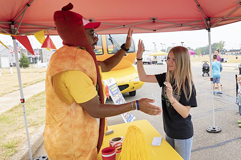 Frankmobile operator Glizzy Garrison put some relish on a series of high fives with Gracie Byrd, 13, of Rock Falls Friday, June 30, 2023. The Oscar Mayer hot dog hot rod cruised into Rock Falls Friday morning to celebrate all things Fourth of July.