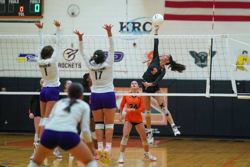 Sandwich's Jordan Bauer (3) goes up for a kill attempt against Plano’s Hennessy Pena (1) and Rita Lauro (17) during a volleyball match at Sandwich High School on Tuesday, Sep 10, 2024.