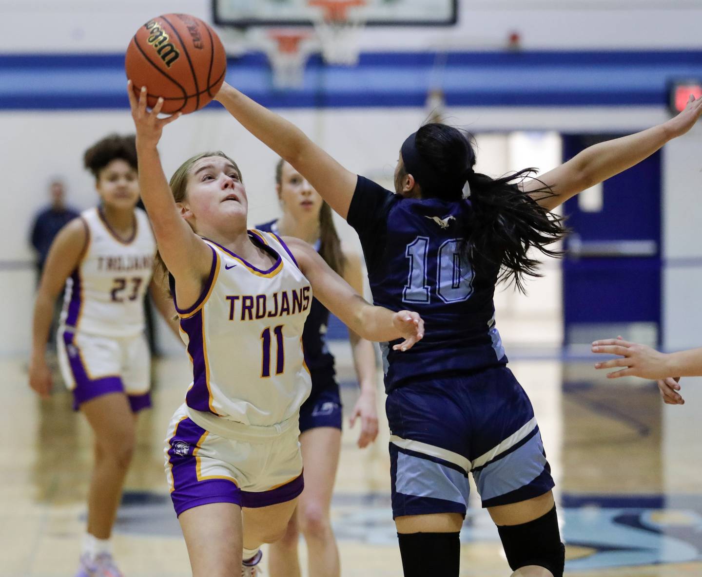 Downers Grove North’s Abby Gross (11) goes for a layup against Downers Grove South’s Elizabeth Rous (10) during a Class 4A Downers Grove South Regional semifinal in Downers Grove, Ill. on Monday, Feb. 13, 2023.