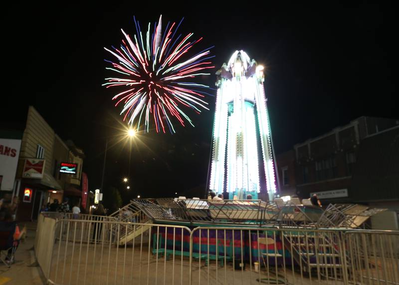A firework illuminates over a carnival ride during the Celebrate La Salle Festival on Friday, June 23, 2023 downtown La Salle.