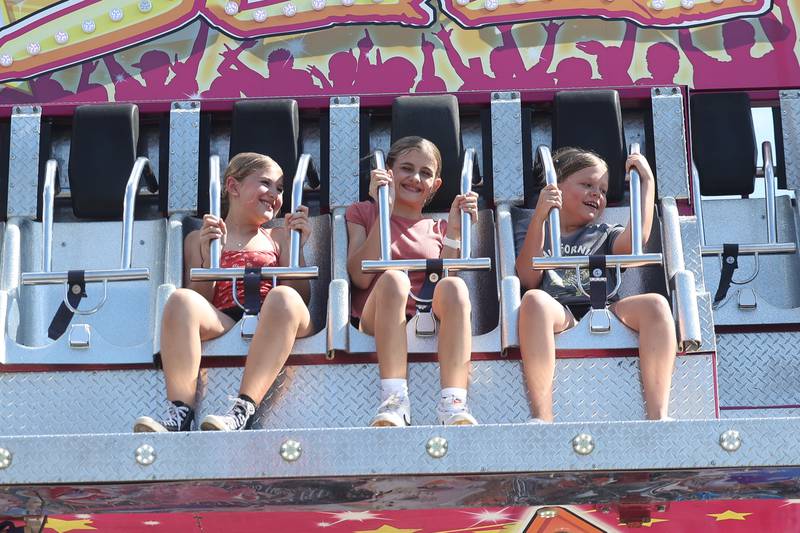 Skylar, left, Charlotte, and Delaney brave one of the extrem rides at Plainfield Fest on Saturday June 29, 2024.