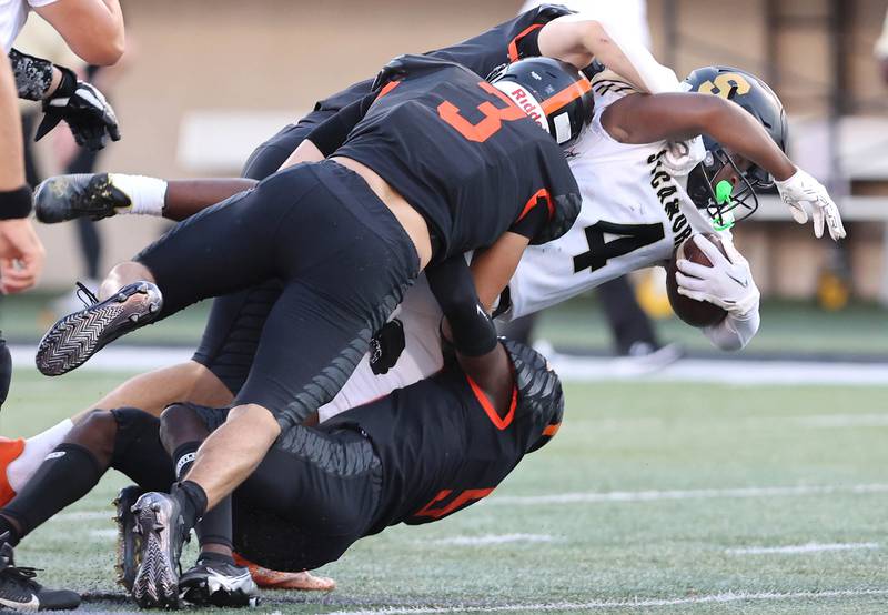 Sycamore's Tyler Curtis is brought down by DeKalb's Ethan Tierney and his teammates during the First National Challenge Friday, Aug. 26, 2022, in Huskie Stadium at Northern Illinois University in DeKalb.