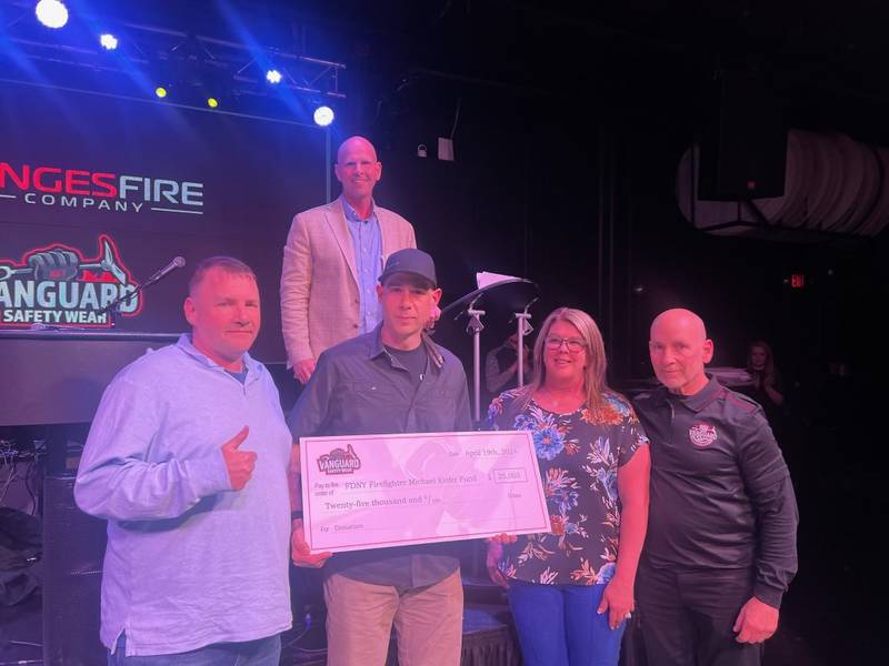 Vanguard Safety Wear & Dinges Fire Co. present a $25,000 check to New York City firefighter Anthony Viverito (front row, second from left). He is pictured with (from left) Ryan Pennington, Nick Dinges, Kim Vaessen and Andy Shapiro.