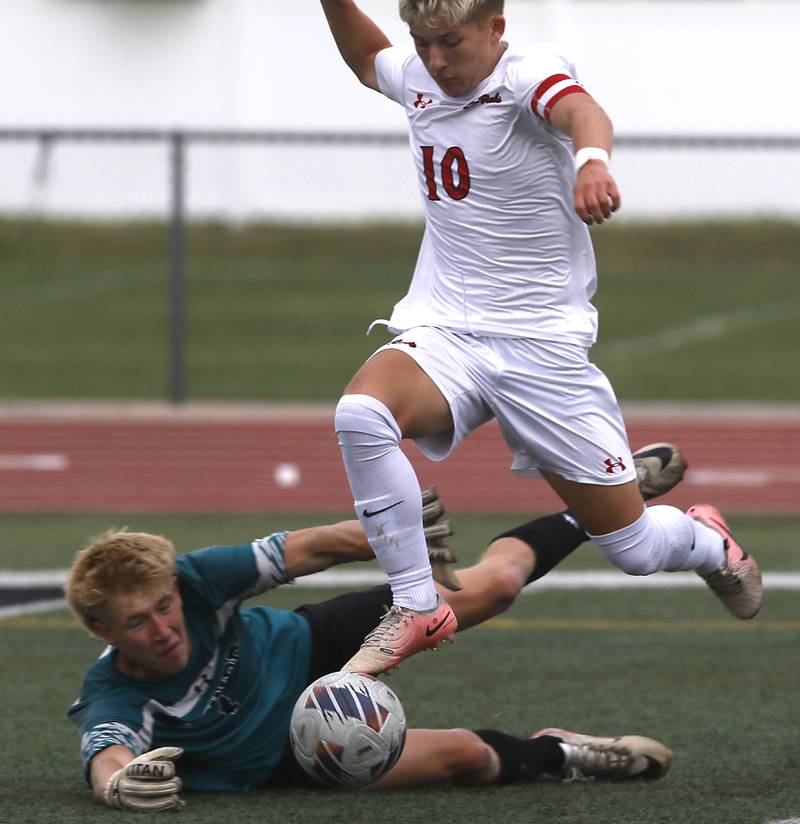 Rockford East's Aidan Aarli flies over Woodstock North goalkeeper Garrett Batdorff during a nonconference soccer match on Thursday, Sept. 5, 2024, at Huntley High School.