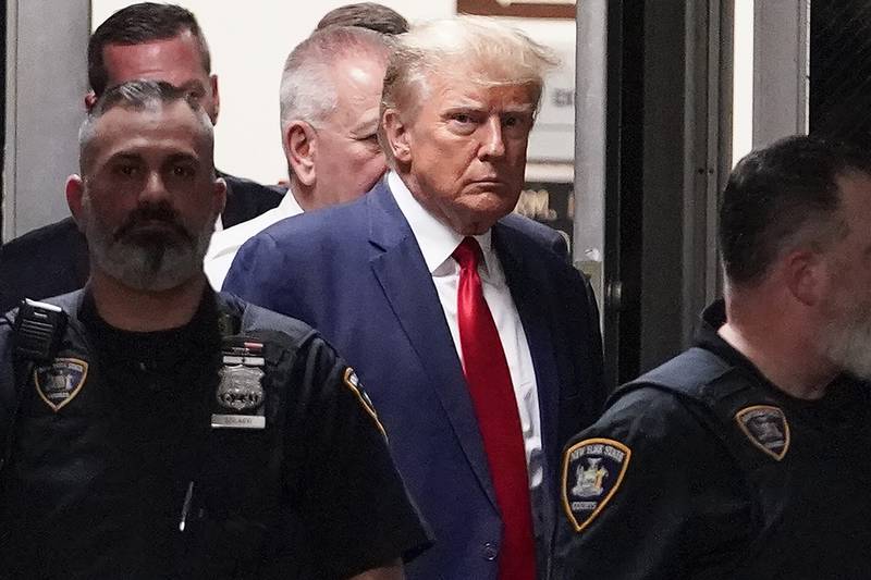 FILE - Former President Donald Trump is escorted to a courtroom, April 4, 2023, in New York. Trump’s bond has been set at $200,000 in the Georgia case accusing the former president of scheming to overturn his 2020 election loss. The bond agreement was outlined in a court filing signed by Fulton County District Attorney Fani Willis and Trump’s defense attorneys. (AP Photo/Mary Altaffer, File)