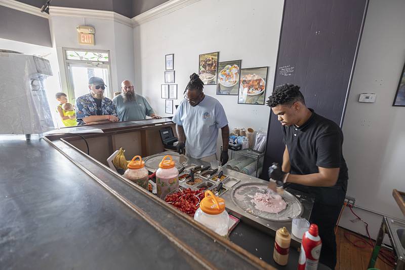On A Roll owner Jullian Horton (left) gets to work making ice cream with Amari Granberry on Monday, July 1, 2024, during a soft opening for the new rolled ice cream shop.