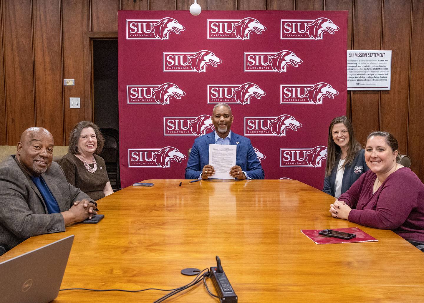 Southern Illinois University Chancellor Austin Lane (middle) signs the Saluki Step Ahead agreement with Illinois Valley Community College during a virtual ceremony Wednesday, May 8, 2024, with (left to right) Wendell Williams, associate vice chancellor for enrollment management;  Sheryl Tucker, dean and vice chancellor for academic affairs;  Sarah Jiter, director of undergraduate admissions;  and Josi Rawls, associate director for transfer relations.