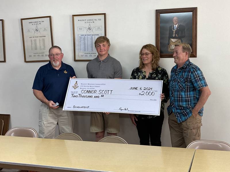 (From left) Bryan Carl, worshipful master of the Walnut Masonic Lodge presents a check to Connor Scott, joined by his parents Tim and Andrea Scott from the Bradford area.