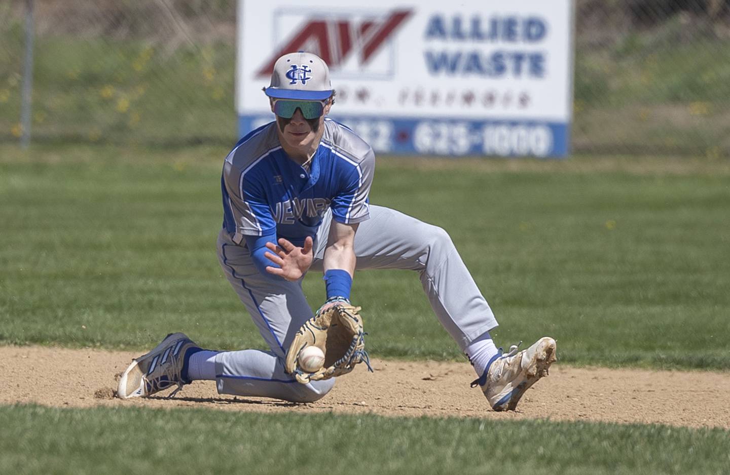 Newman’s Garet Matznick scoops a ball at short against Dixon Saturday, April 13, 2024 at Veterans Memorial Park in Dixon.