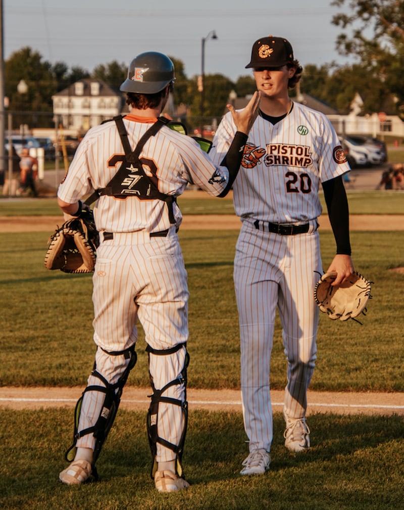 Pitcher Johnny Riva (20) high fives catcher Nick Weaver during the Illinois Valley Pistol Shrimp's 11-0, seven-inning victory over the Burlington Bees on Friday, July 19, 2024 at Schweickert Stadium in Peru.