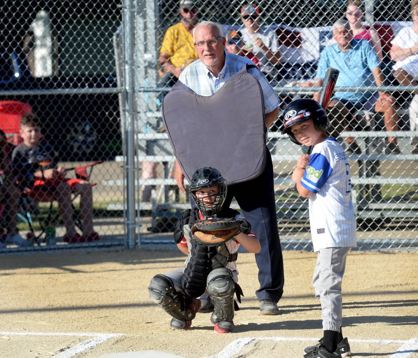 Retired MLB umpire Larry Young was behind the plate for the ceremonial first pitch of the inaugural baseball game between the Oregon Blue and Oregon Red teams following the renaming of the field at Lion's Park in Young's honor on Friday, June 14, 2024. Pictured with Young are catcher Grady Grover and batter Sebastian Murphy. The first pitch was delivered by Huddson Long. Young grew up in Oregon and started his umpiring career calling games for the Oregon Park District at Lions Park.