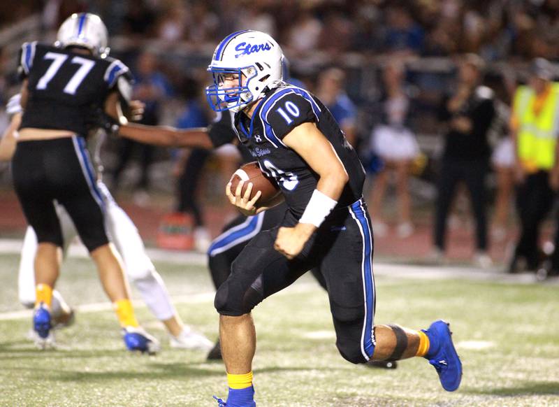 St. Charles North quarterback Ethan Plumb keeps the ball during a game Friday, Sept. 13, 2024 against Wheaton North at St. Charles North.