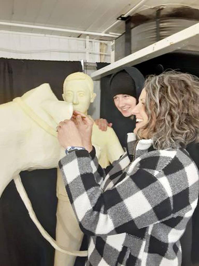 Sarah Pratt and her daughter, Grace, make sure to get all the fine details on their butter cow sculptures.