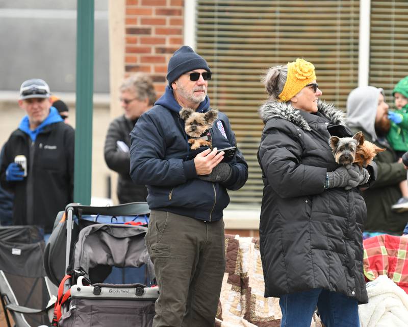 First time spectators Steve and wife Cheryl Nielsen of Moline keep their Yorkshire Terriers, Wrigley, 5, Widget, 12, and Winnie, 11, warm as they watch the Sycamore Pumpkin Festival parade on Sunday Oct. 29, 2023.