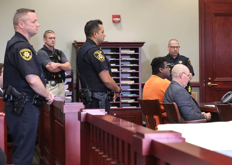 Timothy M. Doll, 29, of DeKalb, and his attorney Andrew Nickel are flanked by DeKalb County Sherriff’s officers including Sheriff Andy Sullivan (left) as they listen to Circuit Court Judge Philip Montgomery read the charges against Doll Wednesday, June 14, 2023, at the DeKalb County Courthouse in Sycamore. Doll is being arraigned on several charges including two counts of first-degree murder in the death of 15-year-old Gracie Sasso-Cleveland of DeKalb.